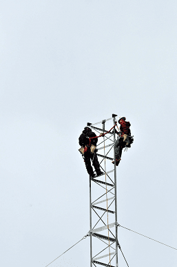 Two Workers at the Top of a Segment of Yonkers Tower Mid-Construction